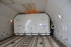 The OSTM/Jason-2 spacecraft packed in a container onboard a Boeing 747.